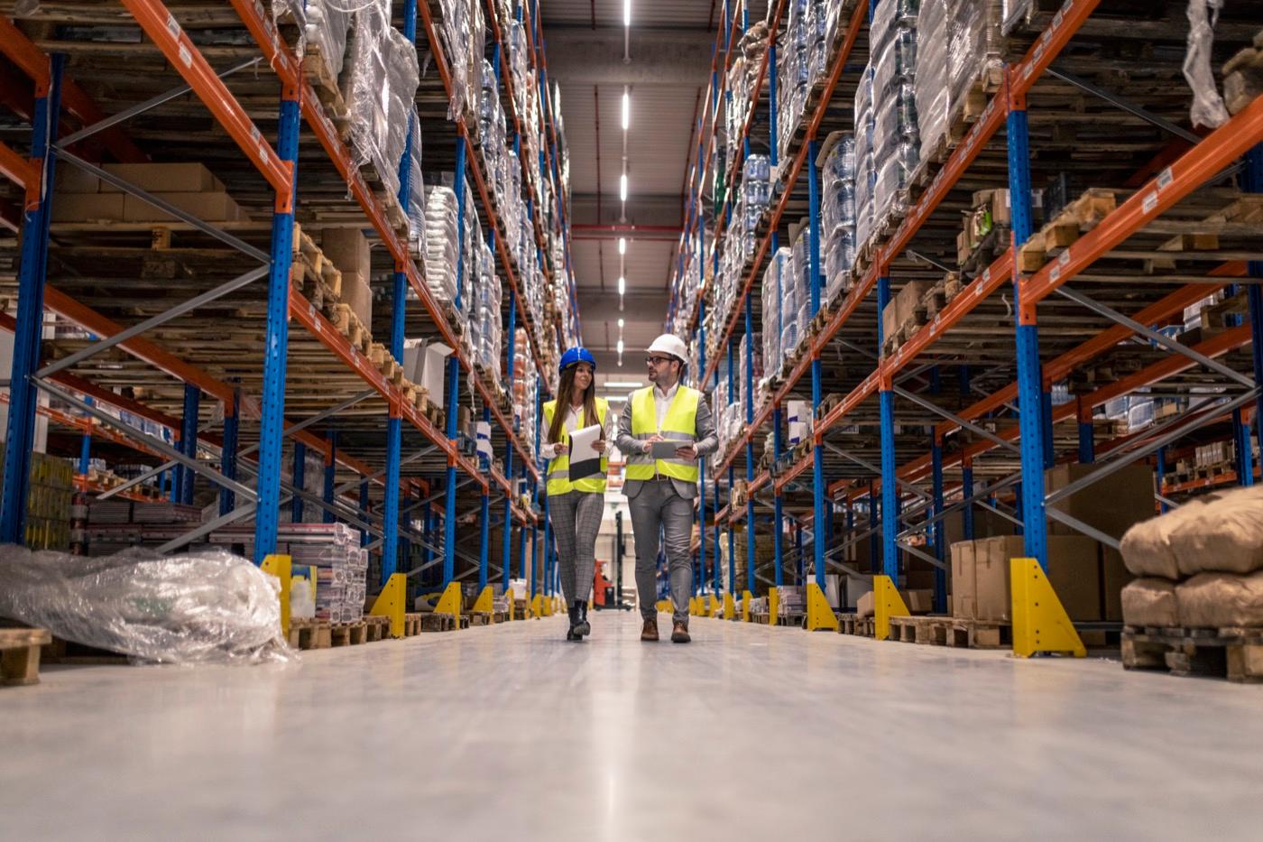 2 employees walking in the warehouse. Tracking inventory has been facilitated with the integration of the ERP into the custom-made software built by Unik Web.